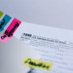 Zbliżenie formularza podatkowego z kolorowymi karteczkami notatek