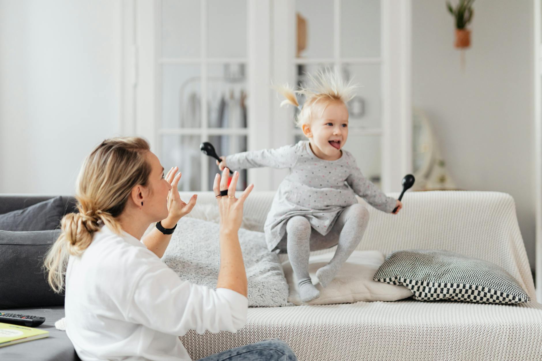 Jak wspierać rozwój mowy u dwulatka w domu i w przedszkolu Mama bawi się z dwuletnią córką na sofie w salonie