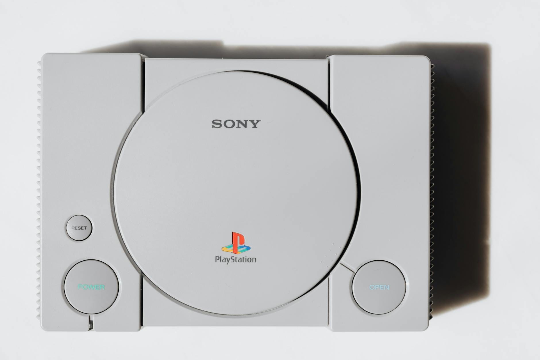 Zbliżenie klasycznej konsoli Sony PlayStation na białym tle